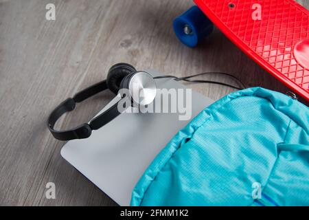Skateboard con cuffie e una borsa - mezzi alternativi di concetto di trasporto Foto Stock