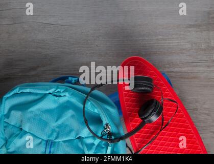 Skateboard con cuffie e una borsa - mezzi alternativi di concetto di trasporto Foto Stock