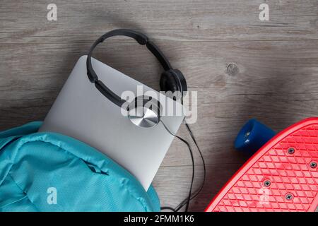 Skateboard con cuffie e una borsa - mezzi alternativi di concetto di trasporto Foto Stock