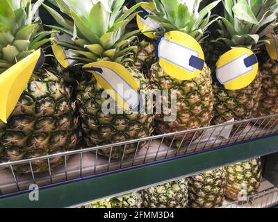 Più ananas fresco si trovano su uno scaffale su un supermercato scaffale con etichette Foto Stock