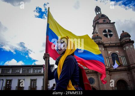 Passo, Narino, Colombia. 9 maggio 2021. Il demostratore Hooded ondeggia la bandiera colombiana nel canto della lotta e supor per lo sciopero nazionale a passo Narino il 9 maggio 2021 Photo by: Camilo Erasso/Long Visual Press Credit: Camilo Erasso/LongVisual/ZUMA Wire/Alamy Live News Foto Stock