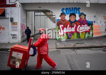 Passo, Narino, Colombia. 9 maggio 2021. Il venditore di strada cammina oltre il murale che dice: ''noi siamo la salute collettiva'' che è stato eseguito dai manifestanti a Pato Narino il 9 maggio 2021 Photo by: Camilo Erasso/Long Visual Press Credit: Camilo Erasso/LongVisual/ZUMA Wire/Alamy Live News Foto Stock