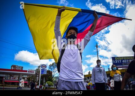 Passo, Narino, Colombia. 9 maggio 2021. Demostrator cammina lungo la strada sventolando la bandiera Colombias a sostegno dello sciopero nazionale a passo Narino il 9 maggio 2021 Photo by: Camilo Erasso/Long Visual Press Credit: Camilo Erasso/LongVisual/ZUMA Wire/Alamy Live News Foto Stock