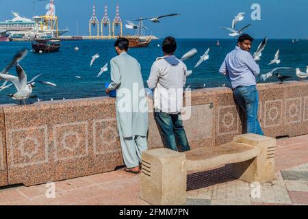 MUSCAT, OMAN - 22 FEBBRAIO 2017: Uomini con gabbiani a Mutrah Corniche a Muscat, Oman Foto Stock