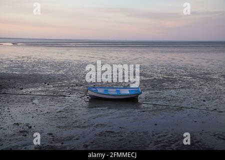 Pellworm, Germania. 10 maggio 2021. Una barca si trova nei mudflats al largo dell'isola di Pellworm. Credit: Marco Brandt/dpa/Alamy Live News Foto Stock