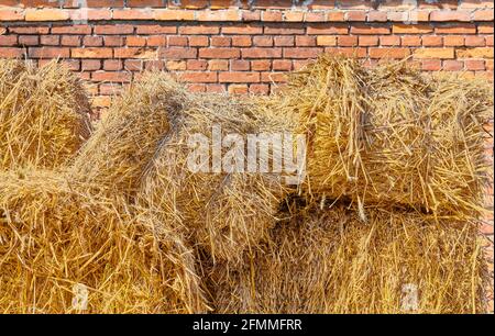 Haystack di fronte a un vecchio edificio in mattoni. Foto Stock
