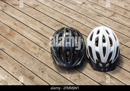 Vista di due caschi per sport attivi su sfondo di legno isolato. Svezia. Foto Stock