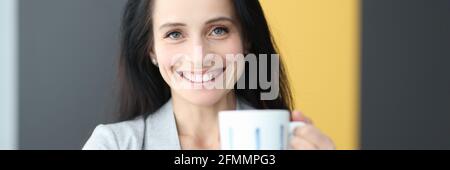 Ritratto di donna sorridente che tiene la coppa in mano Foto Stock