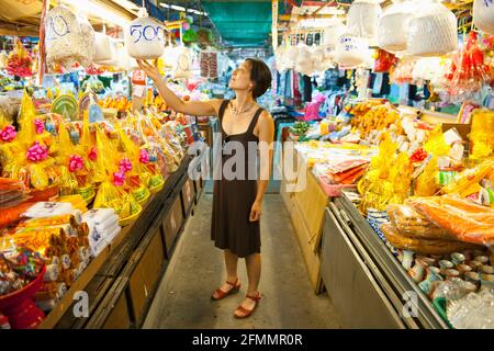 Donna al mercato buddista - shopping per le merci cerimoniali in Chiang mai Foto Stock