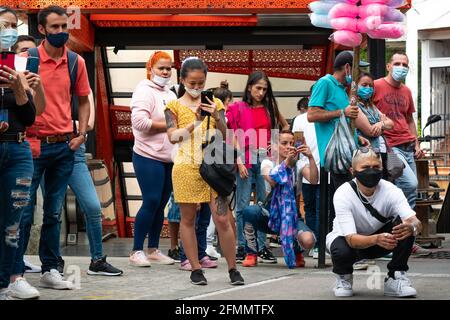 Medellin, Antioquia, Colombia - Marzo 27 2021: Giovane donna asiatica sta scattando foto nel mezzo di un gruppo di donne latine che stanno guardando la danza Foto Stock