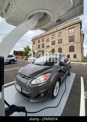 Racine, Wisconsin, Stati Uniti. 10 maggio 2021. Un'auto ibrida plug-in Ford C-Max Energi è collegata alla nuova stazione di ricarica per veicoli elettrici alimentata a energia solare installata dietro il municipio di Racine, Wisconsin la scorsa settimana, lunedì sera 10 maggio 2021. Le stazioni alimentate a energia solare come questa hanno una batteria di riserva, quindi non sono legate alla rete elettrica. La città ordinerà il suo primo veicolo elettrico per il reparto lavori pubblici e prevede l'acquisto di un maggior numero di veicoli elettrici e stazioni di ricarica in tutte le proprietà della città. (Immagine di credito: © Mark HertzbergZUMA Wire) Foto Stock