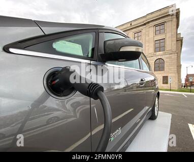 Racine, Wisconsin, Stati Uniti. 10 maggio 2021. Un'auto ibrida plug-in Ford C-Max Energi è collegata alla nuova stazione di ricarica per veicoli elettrici alimentata a energia solare installata dietro il municipio di Racine, Wisconsin la scorsa settimana, lunedì sera 10 maggio 2021. Le stazioni alimentate a energia solare come questa hanno una batteria di riserva, quindi non sono legate alla rete elettrica. La città ordinerà il suo primo veicolo elettrico per il reparto lavori pubblici e prevede l'acquisto di un maggior numero di veicoli elettrici e stazioni di ricarica in tutte le proprietà della città. (Immagine di credito: © Mark HertzbergZUMA Wire) Foto Stock