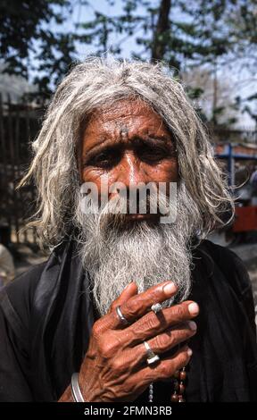 12.03.2010, Haridwar, Uttarakhand, India, Asia - l'uomo con la sigaretta si pone per una foto alla festa di pellegrinaggio indù di massa di Kumbh Mela. Foto Stock