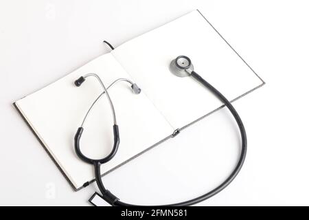 Stetoscopio nero che giace sul diario, medicina. Foto Stock