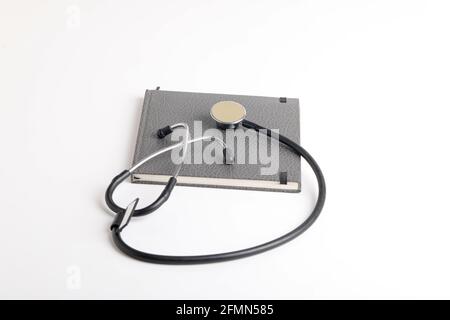 Stetoscopio nero che giace sul diario, medicina. Foto Stock