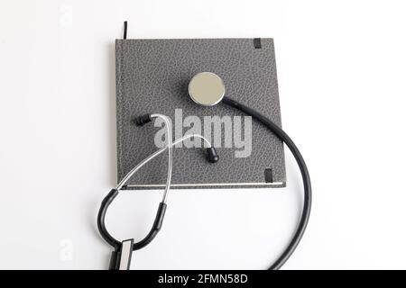 Stetoscopio nero che giace sul diario, medicina. Foto Stock