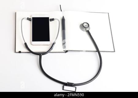 Stetoscopio nero che giace sul diario, medicina. Foto Stock