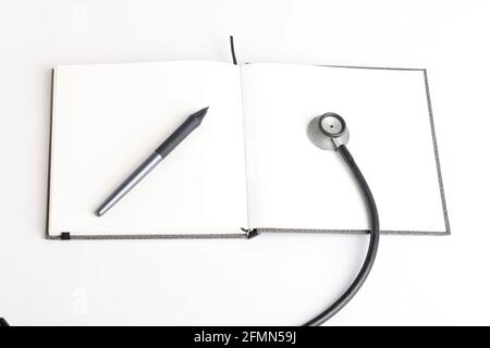 Stetoscopio nero che giace sul diario, medicina. Foto Stock