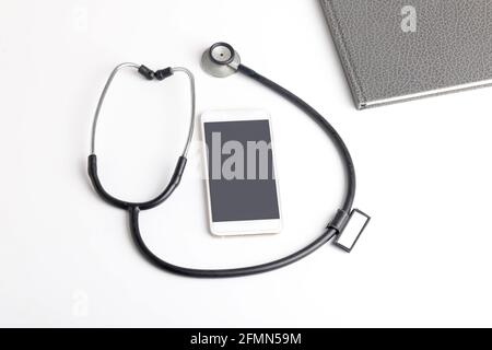 Stetoscopio nero che giace sul diario, medicina. Foto Stock