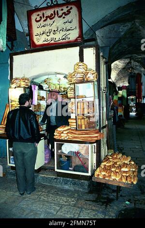 Quartiere musulmano, città vecchia di Gerusalemme - Aprile 1993. Un uomo palestinese che vende pane Ka'ak dal suo piccolo negozio. Foto Stock