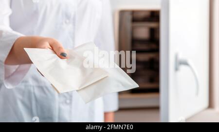 Borsa portamanete per infermiere con strumento medico dentale dopo la disinfezione. Disinfezione di macchine igieniche in ospedale. Dottore in mostra uniforme bianca Foto Stock