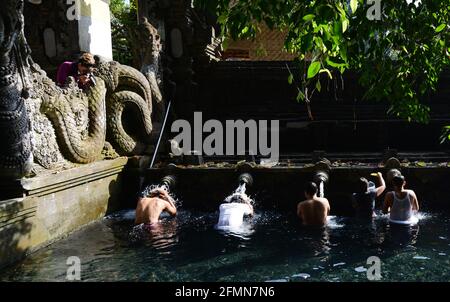 I balinesi si purificano al bagno purificante del tempio Tirta Empowerl di Bali, Indonesia. Foto Stock