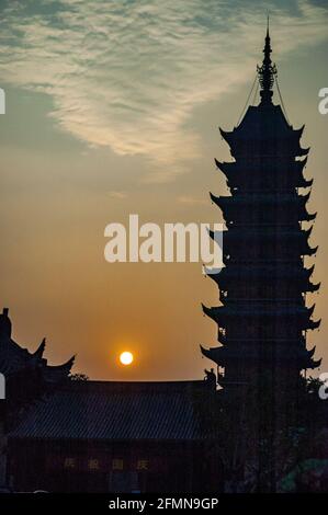 Silhouette della Pagoda quadrata contro il tramonto. Changshu, provincia di Jiangsu, Cina. Foto Stock