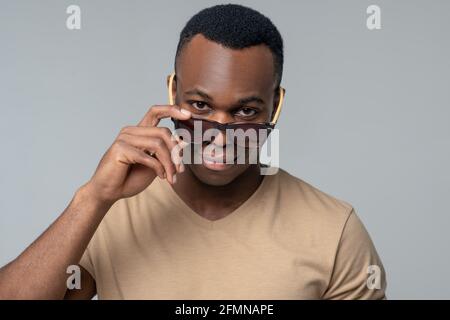Uomo felice in occhiali da sole in studio Foto Stock