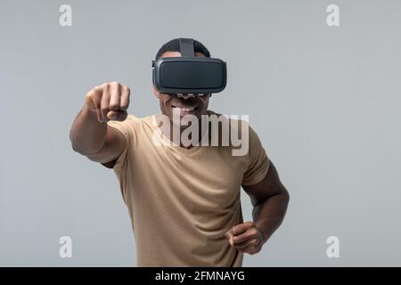 Uomo allegro in occhiali VR che agita i pugni Foto Stock