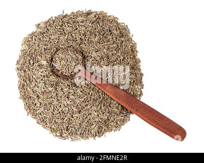 vista dall'alto del cucchiaio di legno sul mucchio di semi di zera di kala (elwendia persica, cumino nero) su sfondo bianco Foto Stock