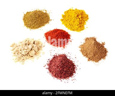 sei spezie in polvere di vari colori tagliate su sfondo bianco Foto Stock