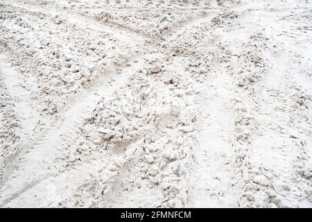 cingoli pneumatici sulla superficie coperta da neve della strada urbana su giorno invernale Foto Stock