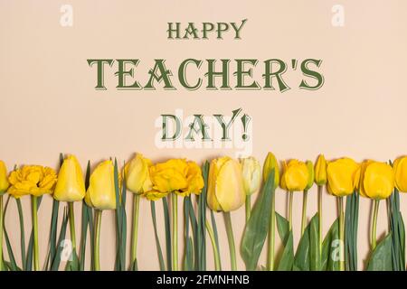 Biglietto d'auguri orizzontale con l'iscrizione Happy Teachers Day su sfondo beige con tulipani gialli. Foto Stock