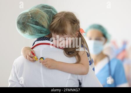 Infermiera che tiene la bambina con gli occhi chiusi in clinica Foto Stock