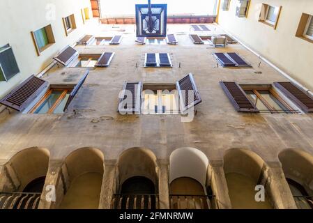 FIRENZE, ITALIA - 24 agosto 2020: Firenze, Toscana/Italia - 24.08.2020: Cortile con appartamenti, finestre con persiane, aria condizionata e un lante Foto Stock