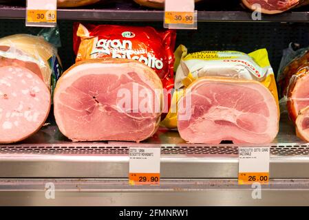 FIRENZE, ITALIA - 24 agosto 2020: Firenze, Toscana-Italia - 08/24/2020: Bancone refrigerato con vari prosciutti cotti e salsicce nella loro plastica pa Foto Stock