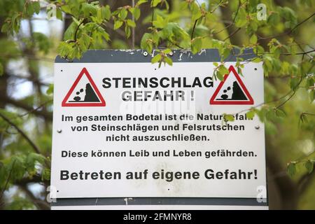 Thale, Germania. 07 maggio 2021. Un cartello di avvertimento nella valle del Bode indica i possibili pericoli derivanti dalla caduta di rocce. I sentieri escursionistici della Valle del Bode sono controllati regolarmente. A causa dei maggiori pericoli, i percorsi possono essere inseriti solo a proprio rischio. Credit: Fahren/dpa-Zentralbild/ZB/dpa/Alamy Live News Foto Stock