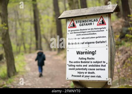 Thale, Germania. 07 maggio 2021. Un cartello di avvertimento con l'iscrizione 'pericolo di caduta roccioso!' Nella Valle di Bode. Il clima primaverile attira ancora una volta molte persone nella natura. Pertanto, i sentieri escursionistici sono controllati regolarmente. A causa dell'aumento del rischio di caduta di rocce, alcuni sentieri possono essere immessi solo a proprio rischio. Credit: Fahren/dpa-Zentralbild/ZB/dpa/Alamy Live News Foto Stock