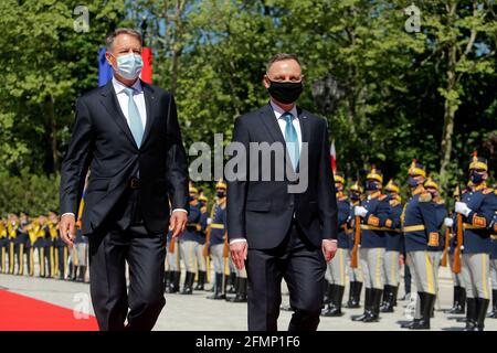 Bucarest, Romania. 10 maggio 2021. Il presidente rumeno Klaus Iohannis (L) e il suo omologo polacco Andrzej Duda hanno recensito una guardia d'onore durante una cerimonia di benvenuto al Palazzo Presidenziale di Cottoceni a Bucarest, Romania, 10 maggio 2021. Credit: Cristian Cristel/Xinhua/Alamy Live News Foto Stock