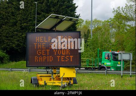 Beaconsfield, Buckinghamshire, Regno Unito. 11 Maggio 2021. Anche se le restrizioni Coronavirus Covid-19 sono state revocate e il livello è stato ora declassato al livello 3, ci sono ancora preoccupazioni dal Chief Medical Officer Chris Whitty che la variante indiana potrebbe portare a un'altra nuova ondata di Covid-19 questa estate in Inghilterra. Un enorme segno LED messo in su dal Consiglio di Buckinghamshire ricorda alle persone di contribuire a fermare la diffusione e ottenere un test rapido. Credit: Maureen McLean/Alamy Live News Foto Stock