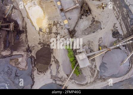 Nella sono in funzione le macchine e i dumper con vista panoramica aerea miniera di cava per attrezzatura speciale Foto Stock