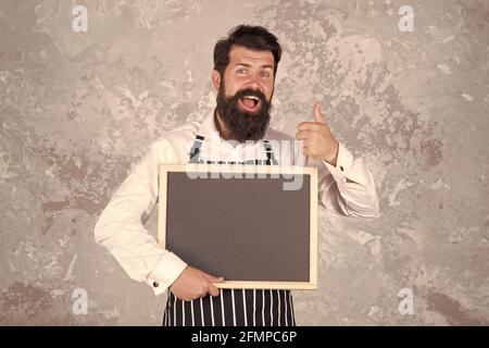 cuoco mostra tavola vuota. pollice in su per successo. miglior menu chef. lavagna con spazio copia per il testo. panettiere professionale in grembiule. buon barista con Foto Stock