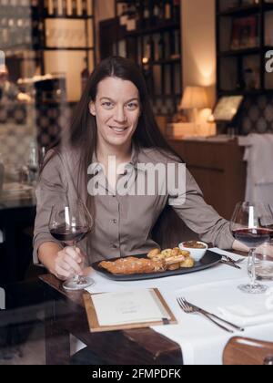 Ritratto del proprietario del Ristorante Brunello di Milano con uno dei loro piatti tradizionali: La cotoletta milanese servita con pentola francese al forno Foto Stock