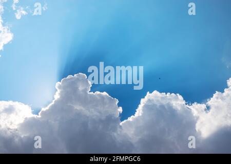 Sun, sunbeam e le nuvole nel cielo blu Foto Stock