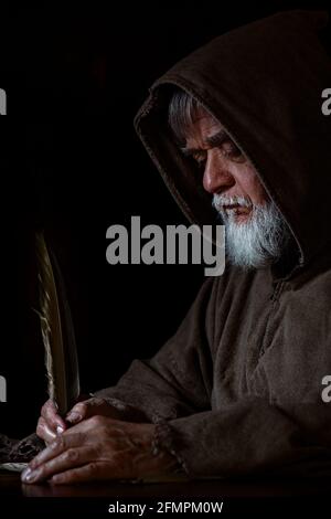 Mendicante nel Medioevo scrive una lettera Foto Stock