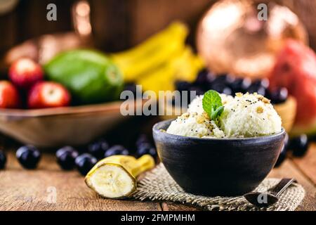 gelato alla banana vegan senza latte in ciotola di argilla fatta a mano, cibo sano senza ingredienti animali Foto Stock