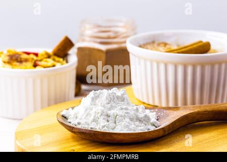 cucchiaio di amido di mais, farina di mais usata per fare creme o come addensante. Sfondo bianco, spazio di copia Foto Stock