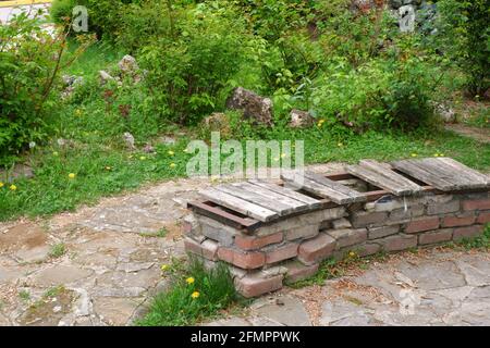 Vecchio panca fatto di mattoni con parti di legno perse a. parcheggio Foto Stock