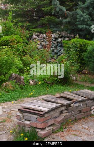 Vecchio panca fatto di mattoni con parti di legno perse a. parcheggio Foto Stock