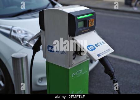 DUBLINO, IRLANDA - 28 ottobre 2019: Vista in primo piano della stazione di ricarica ECB sulla strada con auto elettriche collegate a Dublino, Irlanda. Selectiv Foto Stock